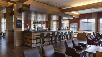 A modern bar area with wooden beams, a bar counter, and seating.