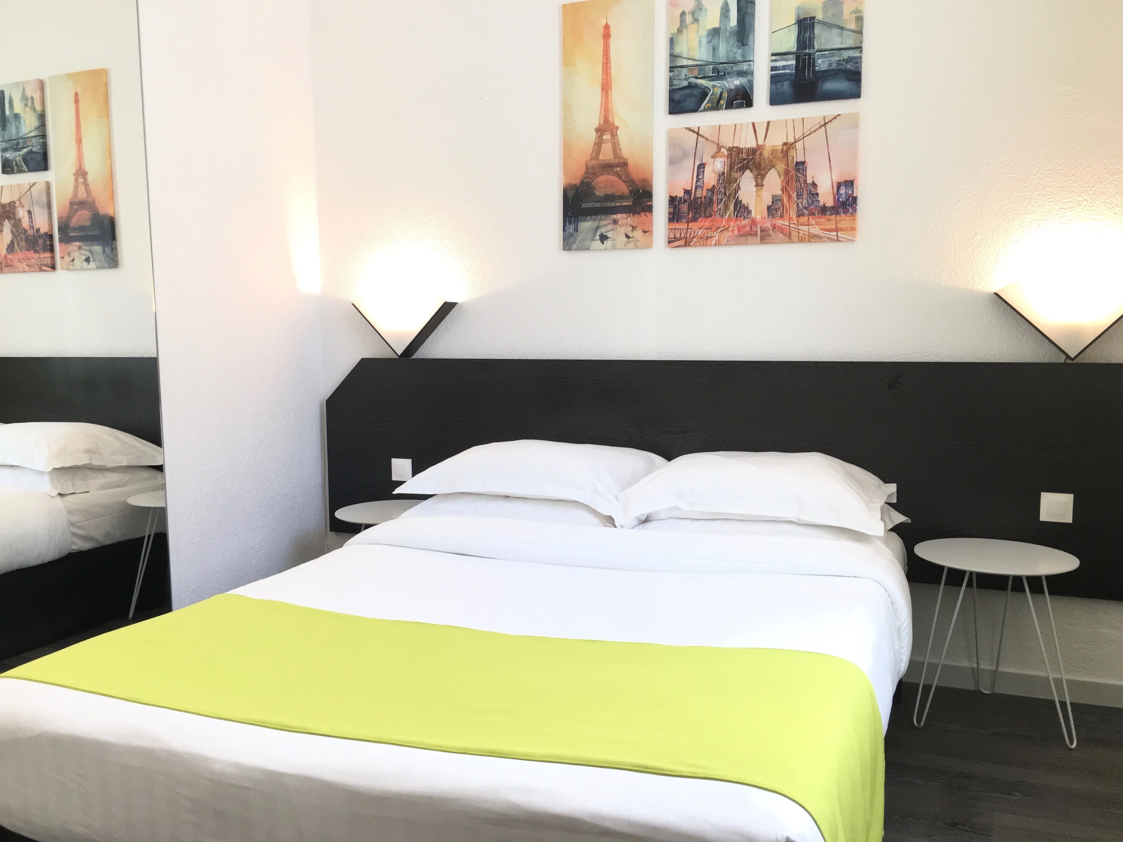 A hotel room with a bed, two bedside tables, and a nightstand.