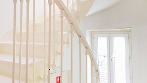 A white spiral staircase with a fire extinguisher sign on the wall. - Appart Hôtel Boulogne Résidence (Boulogne-Billancourt)
