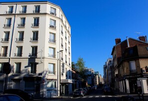 A multi-story hotel with balconies, a stop sign, and a clear blue sky.