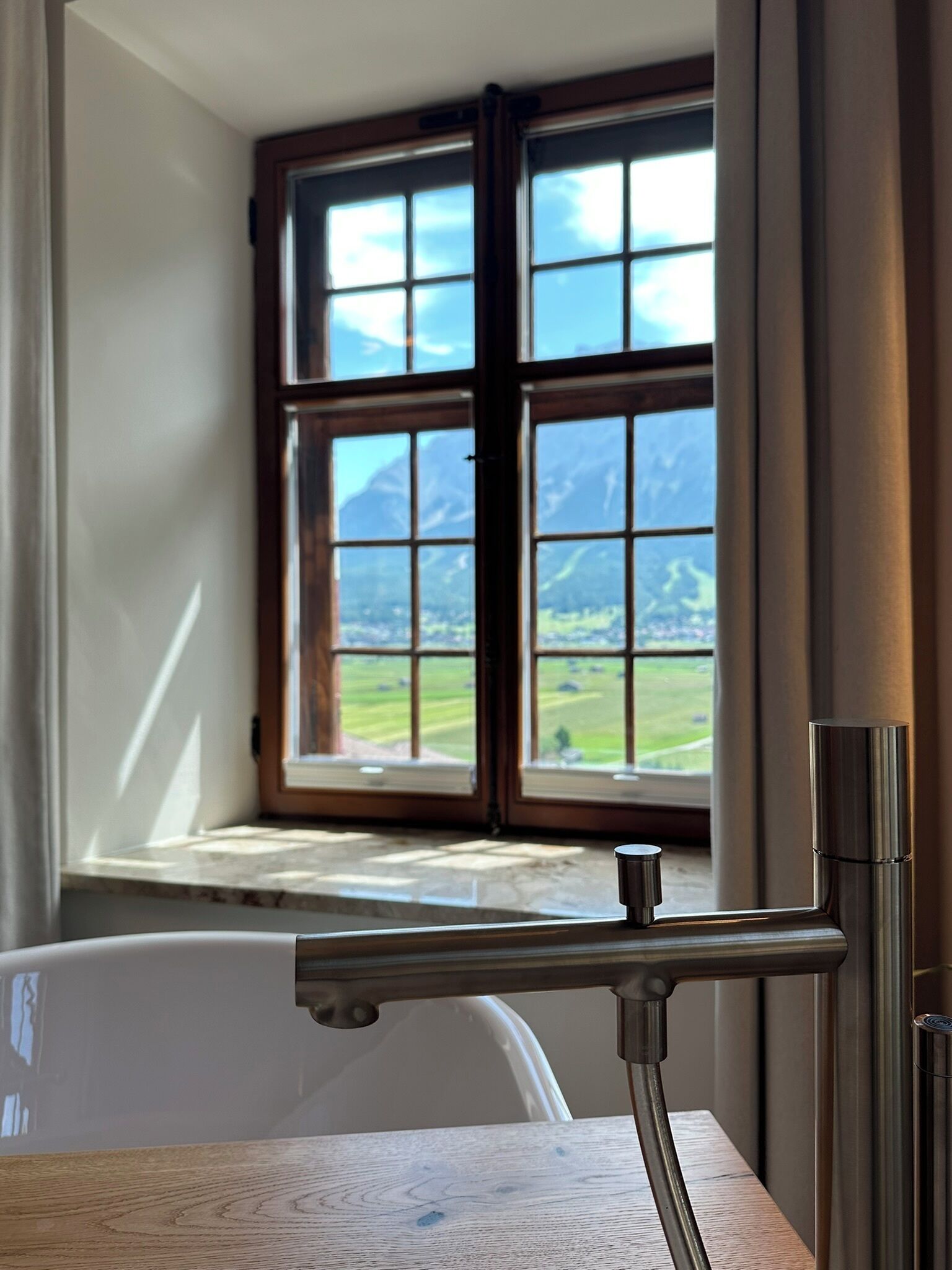 A bathroom with a window view of a mountainous landscape.