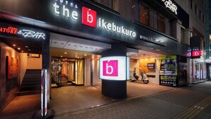 A hotel entrance with a prominent 'b' sign, a staircase, and a scooter parked outside. - the b ikebukuro (Tokyo)