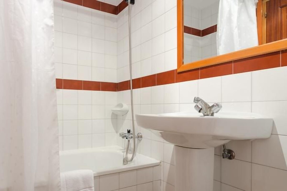 Un baño con bañera, lavabo y ducha.