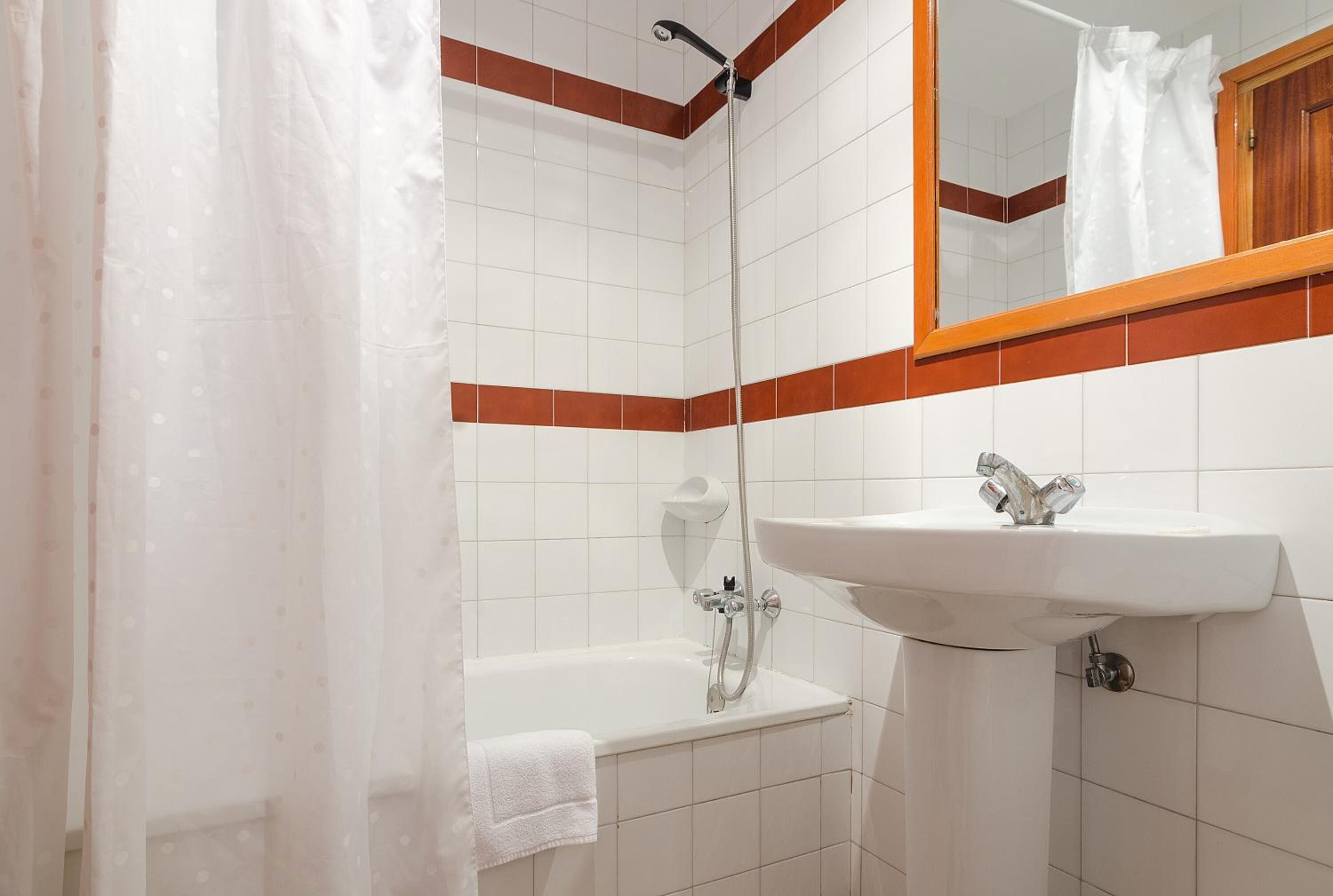 A bathroom with a bathtub, a sink, and a shower.