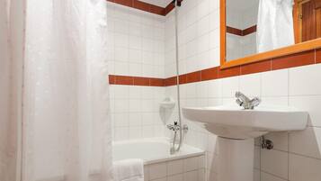 Un baño con bañera, lavamanos y ducha.