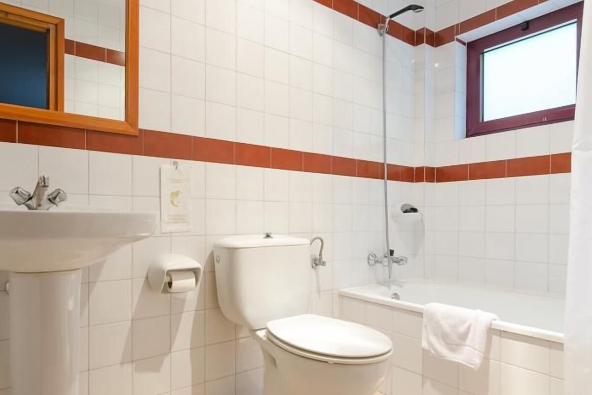 Baño con lavabo, inodoro y ducha.