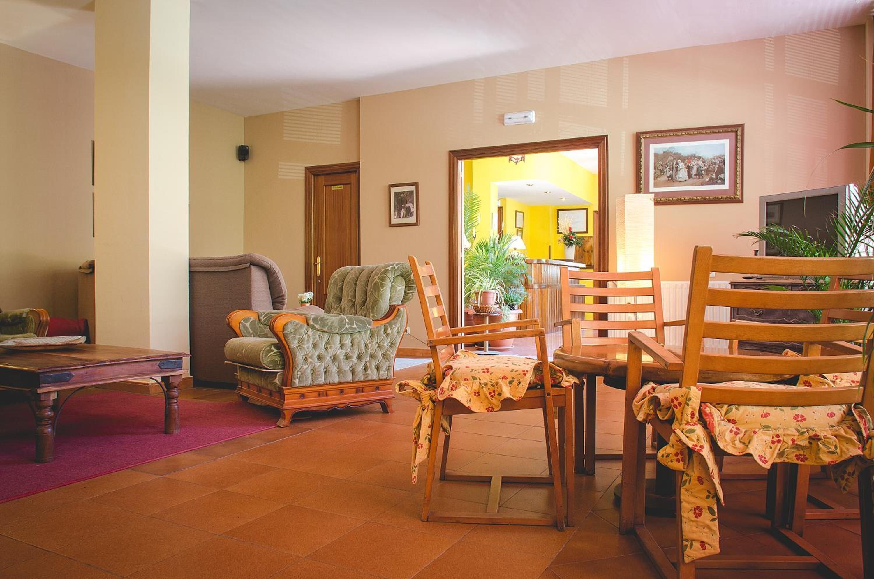 Un salon avec un canapé, des fauteuils, une table basse et un téléviseur.