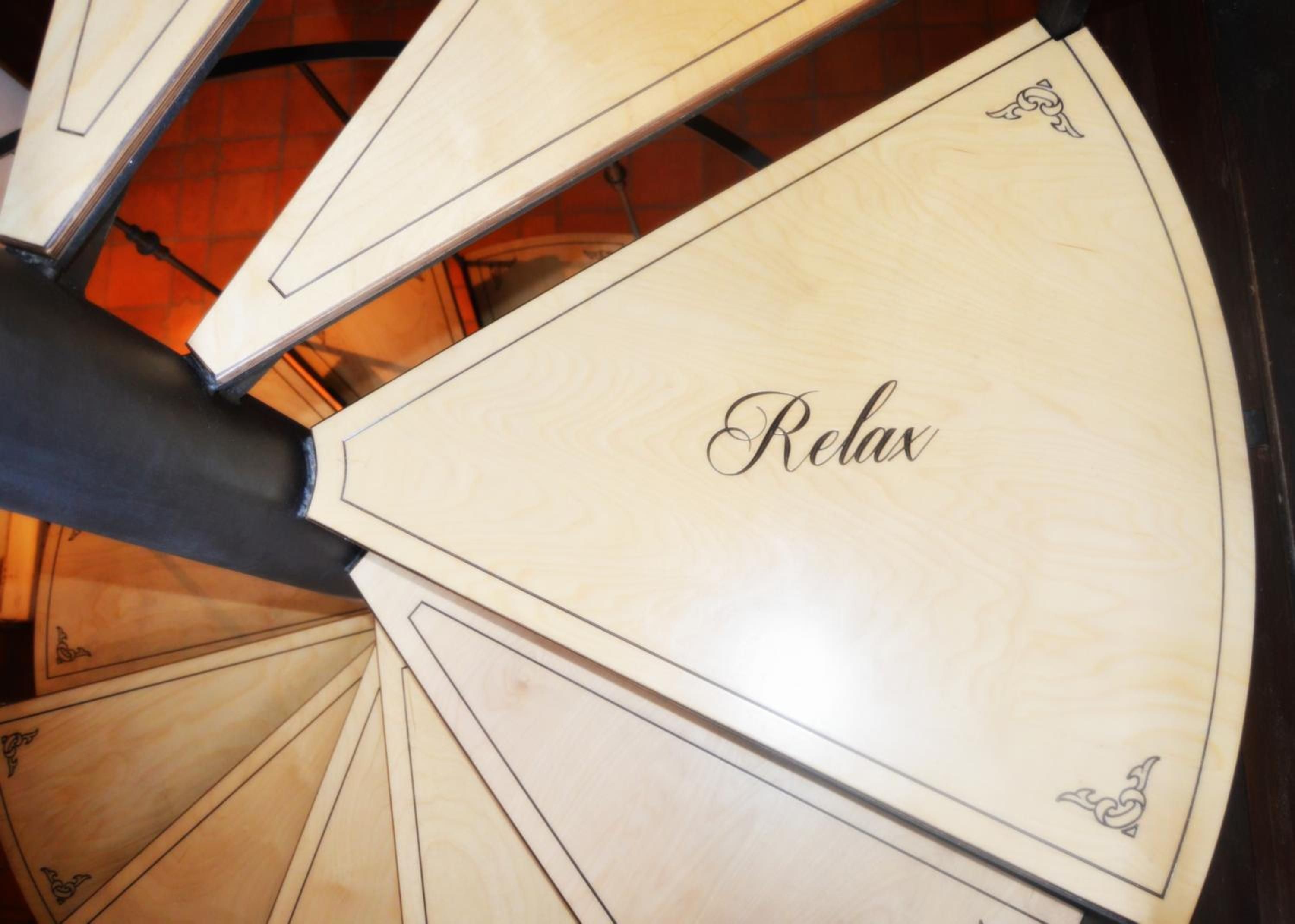 A spiral staircase with a handrail and steps that have a light wood finish.