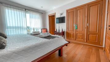 Ein Hotelzimmer mit Bett, Holzschrank und Fernseher an der Wand.