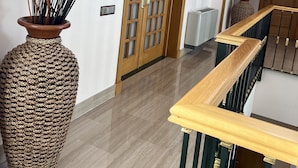 A hallway with a large woven vase, a wooden door with glass panels, and a staircase with a wooden handrail. - The Marbella Heights Boutique Hotel (Marbella)