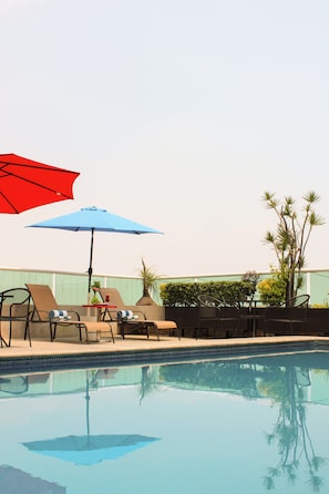 Una piscina al aire libre, sombrillas