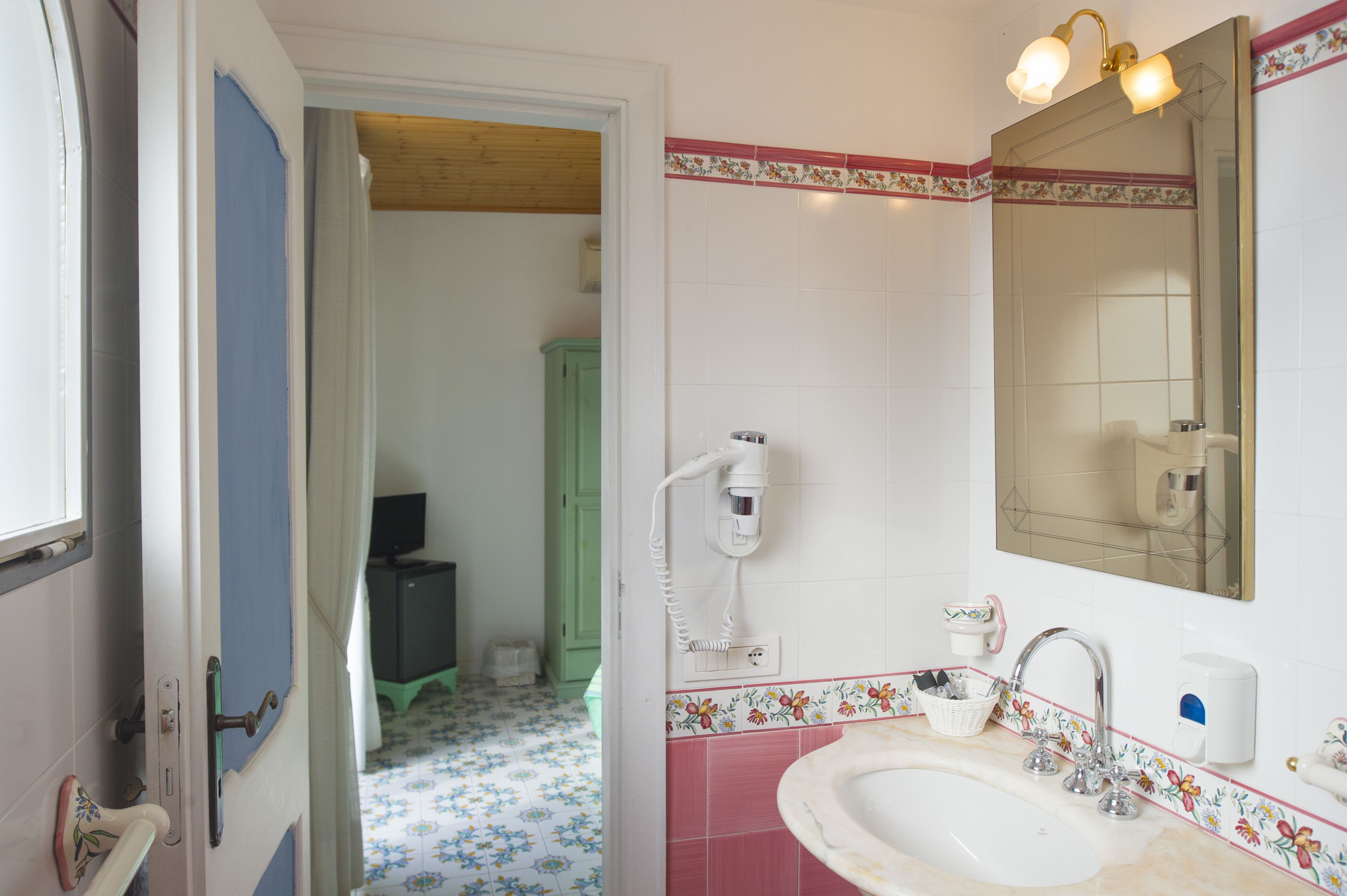 A bathroom with a sink, mirror, and hairdryer.