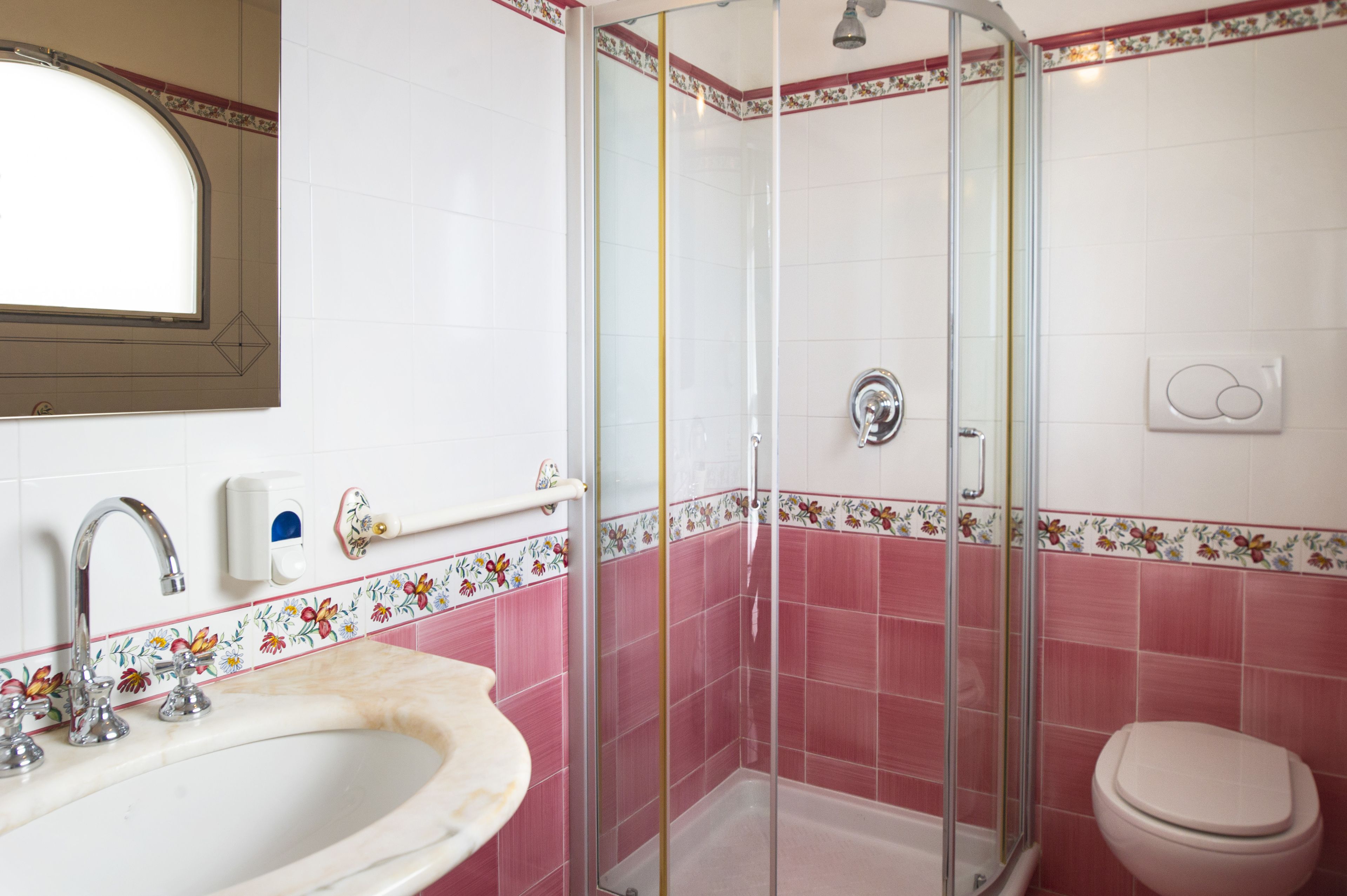 Une salle de bain équipée d’une douche, d’un lavabo, de toilettes et d’un miroir.
