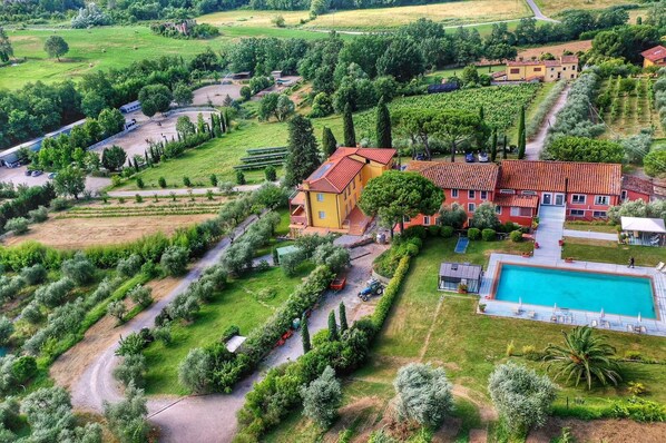 Situated in a lush landscape, this property features a swimming pool with sun terrace, surrounded by gardens and pathways.