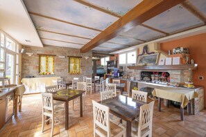 Cozy dining area with a brick fireplace, wooden table, and comfortable seating.