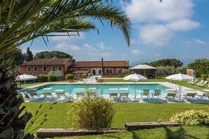 Relax by the pool surrounded by lush greenery and comfortable lounge chairs.