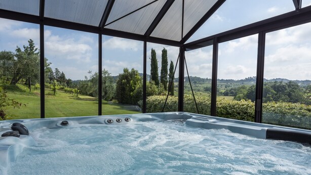 A hot tub with a view of a lush green landscape and hills. - Agriturismo Corte Benedetto (Capannori)