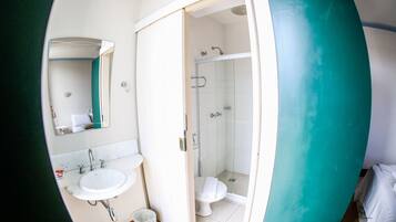 A bathroom with a sink, mirror, toilet, and shower.