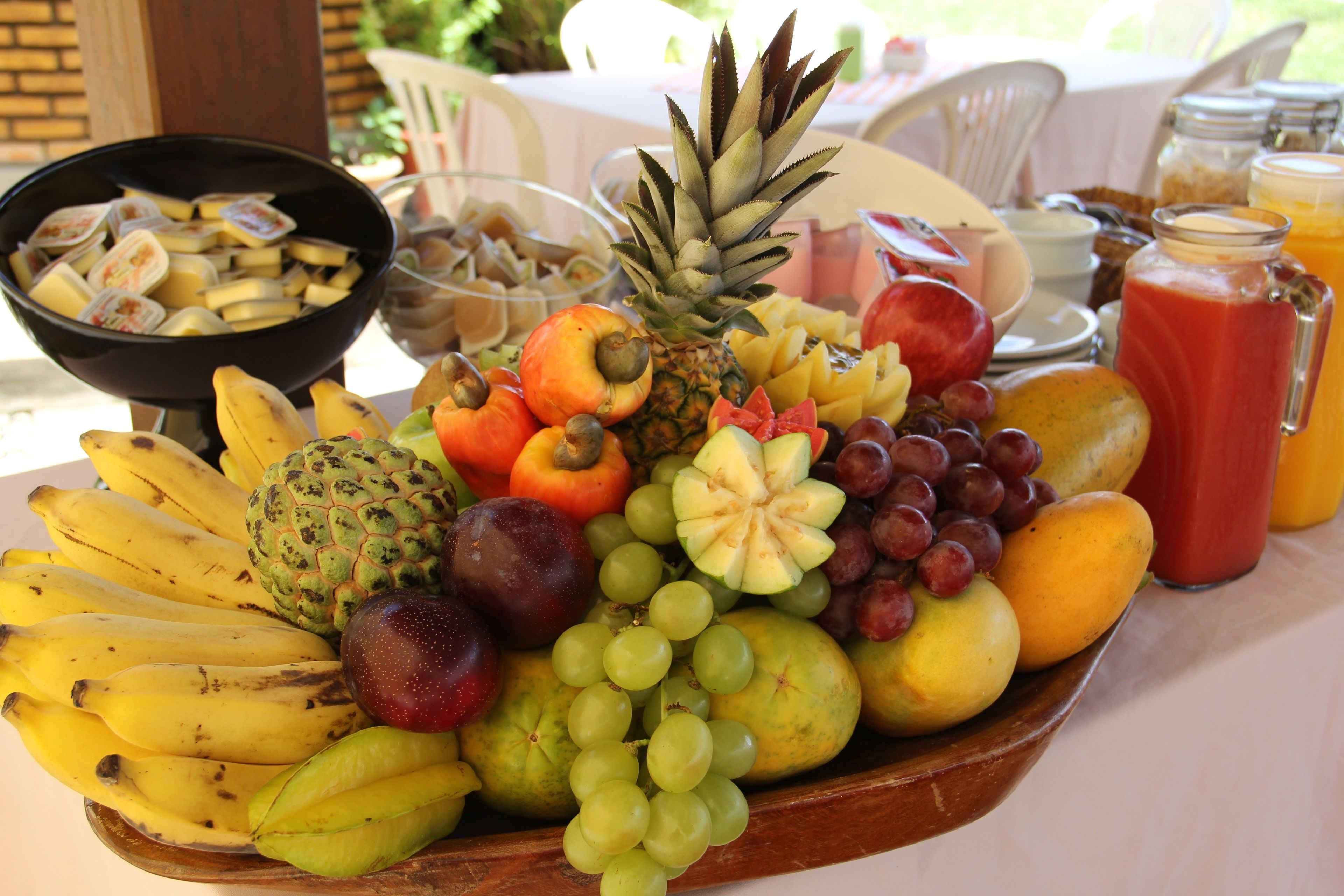 A fruit platter with bananas, grapes, apples, and other fruits on a table.
