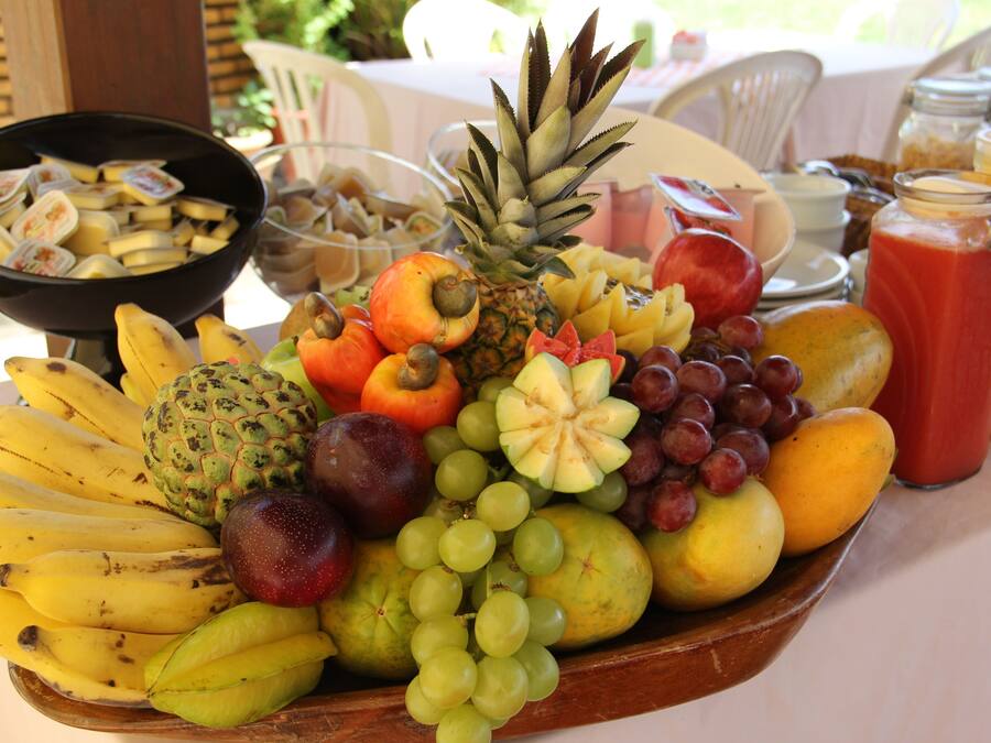 A fruit platter with bananas, grapes, apples, and other fruits on a table.