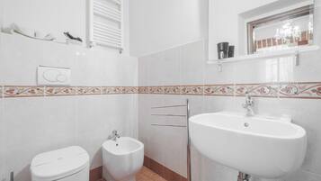 A bathroom with a toilet, bidet, and sink.