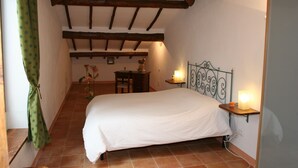 A bedroom with a bed, a nightstand, a desk, and a chair. - La Coperta Ricamata (Siena)