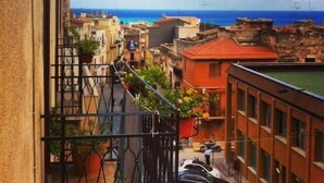 A balcony with a view of a coastal cityscape, including buildings and the sea. - Case D'Anna (Castellammare del Golfo)