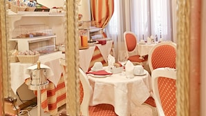 Un comedor con barra de buffet, que incluye una máquina de café y diferentes opciones de comida.