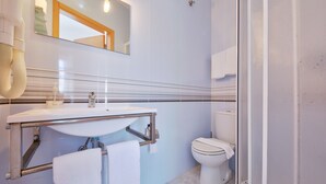 Une salle de bain moderne avec un lavabo, un miroir et des toilettes.