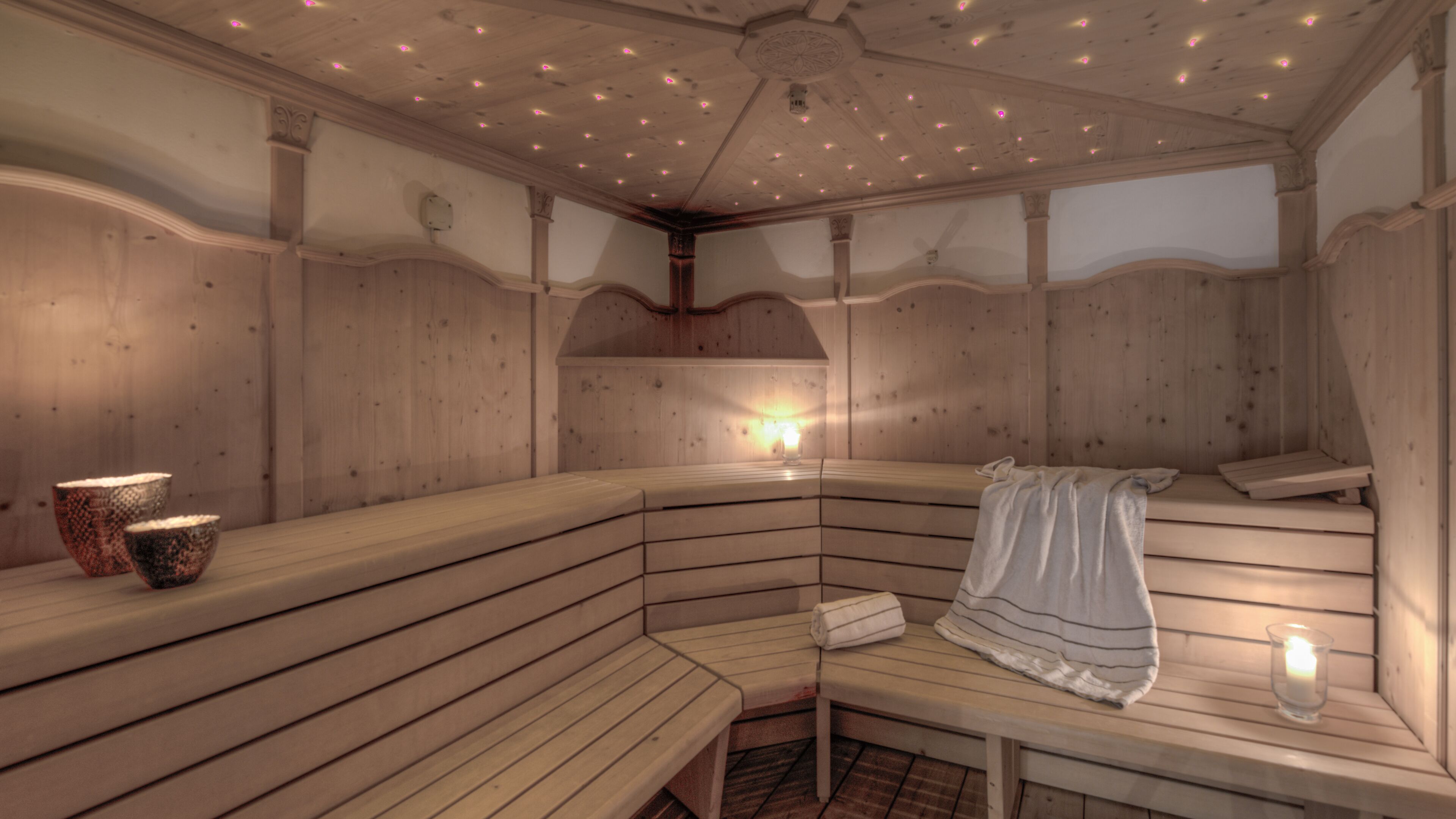 A sauna with wooden benches and a bench with a towel.