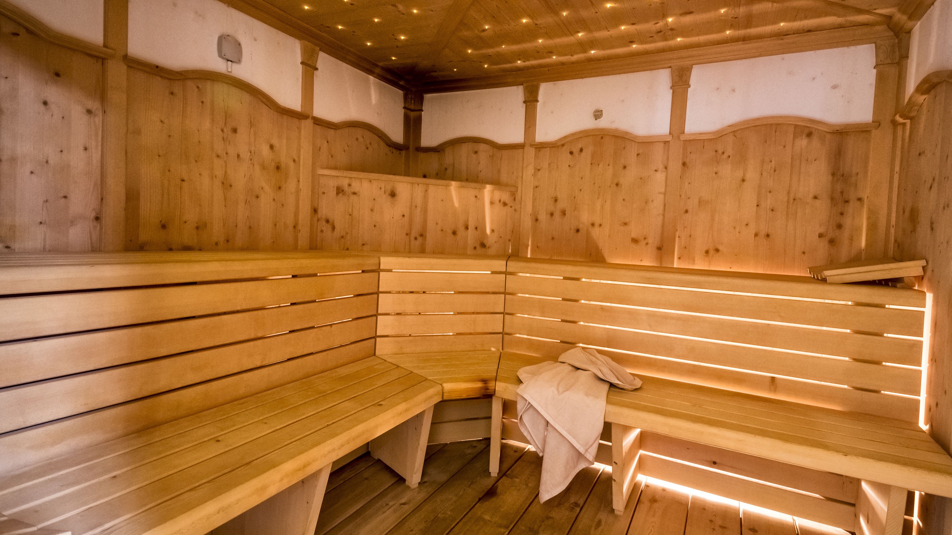 A sauna with wooden benches and benches with towels.
