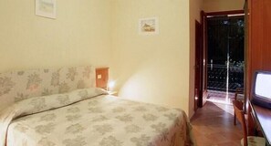 A bedroom with a bed, a nightstand, a framed picture on the wall, and a view of the outside balcony. - Hotel Ristorante Portole (Cortona)