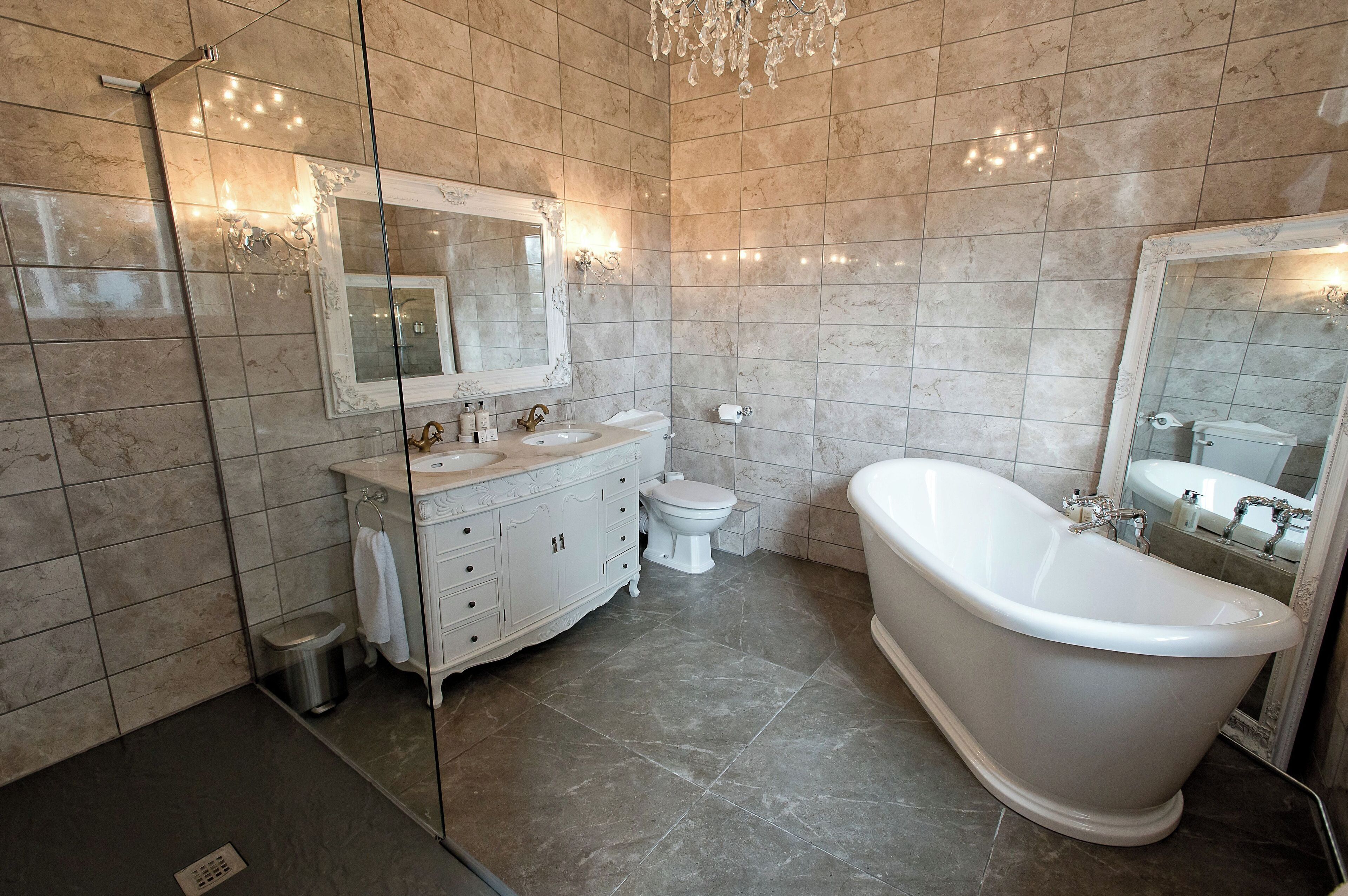 Un bany modern amb una banyera independent, un lavabo amb doble rentapel i un vàter.