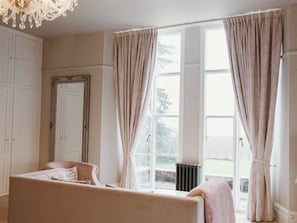 A room with a large window, a radiator, a bed, and a wardrobe. - Glewstone Court Country House Hotel (Ross-on-Wye)