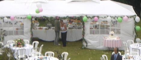 Evento al aire libre con carpas, mesas y sillas dispuestas para los invitados.