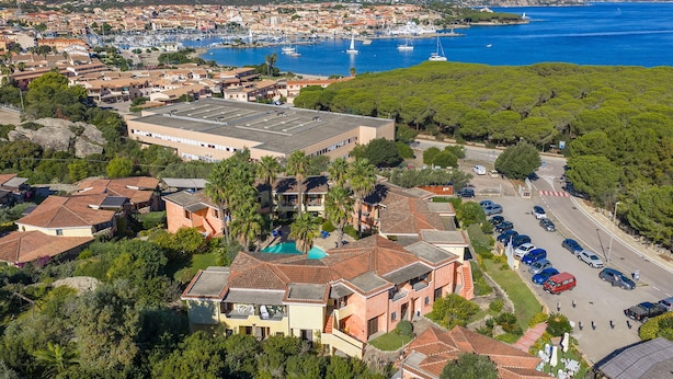 An aerial view of a coastal town with a marina, residential buildings, and a large parking area. - Palau Green Village (Palau)
