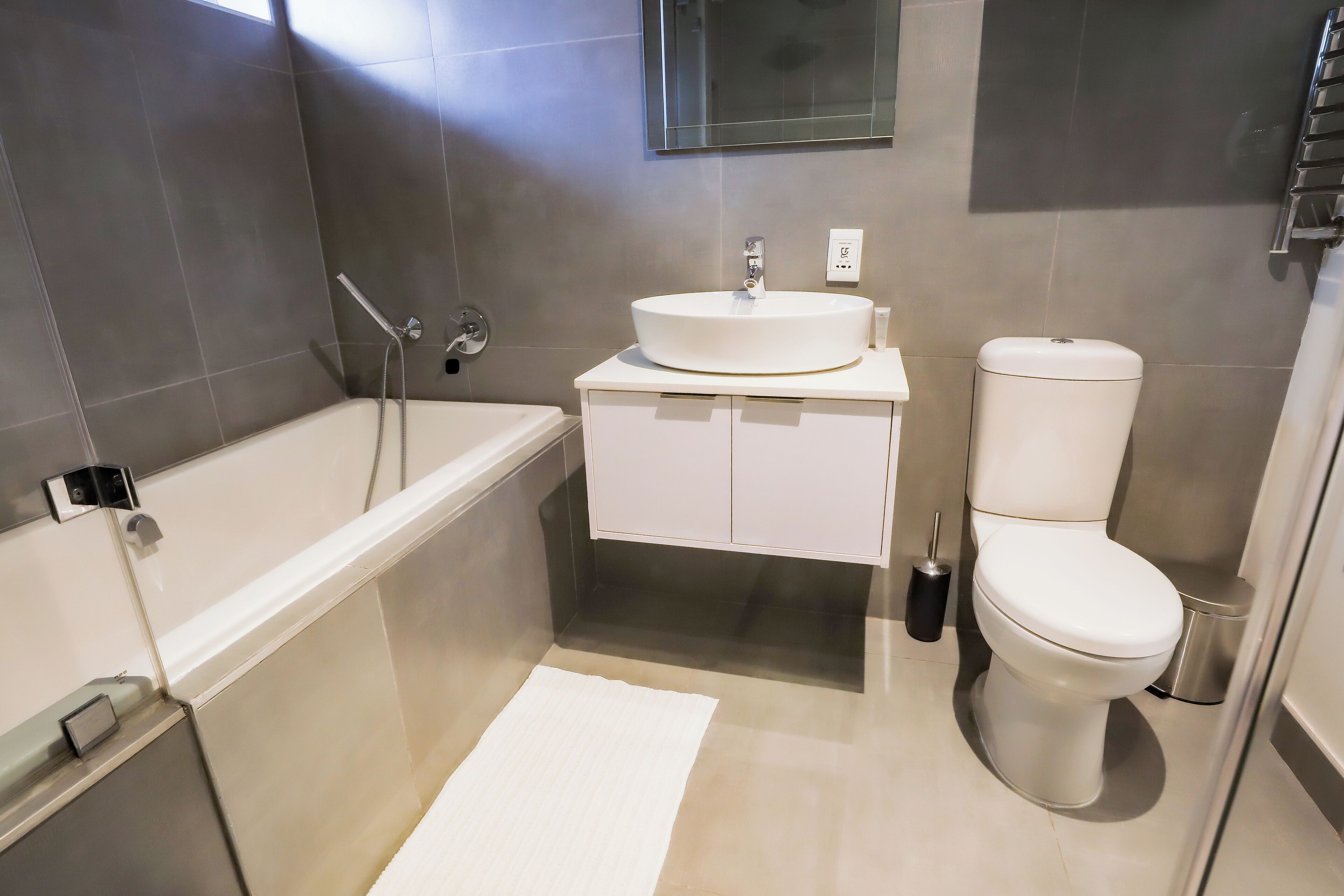 A modern bathroom with a bathtub, sink, and toilet.