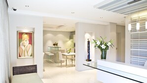 Een modern interieur met een eetgedeelte, een receptiebalie en een gang naar een slaapkamer.