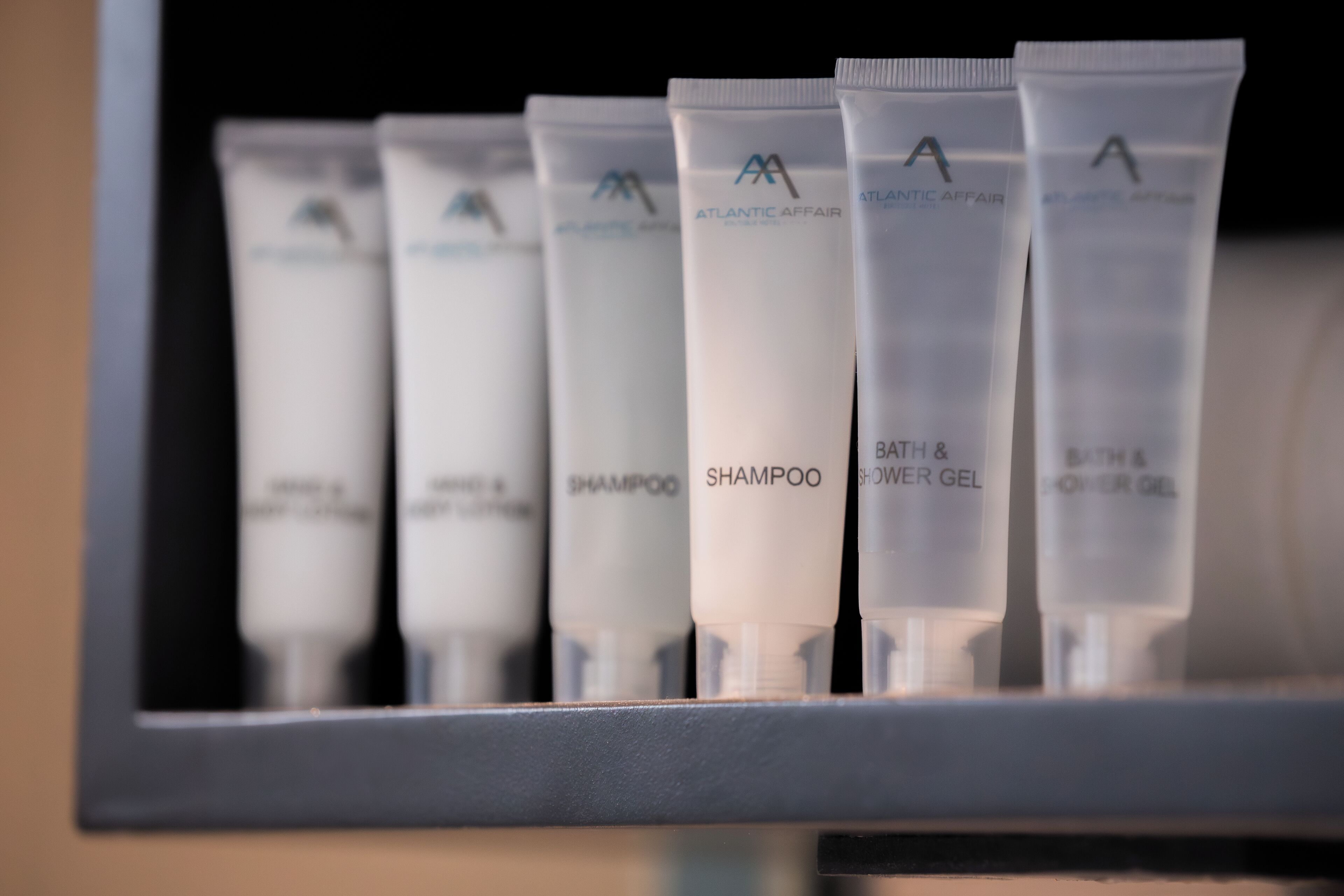 Une étagère contenant plusieurs tubes de produits capillaires, tous étiquetés « Atlantic Affair ».