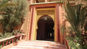 Ein traditionelles Gebäude mit einem markanten Eingang, einer Treppe, die zum Eingang führt, und einem Schild darüber.