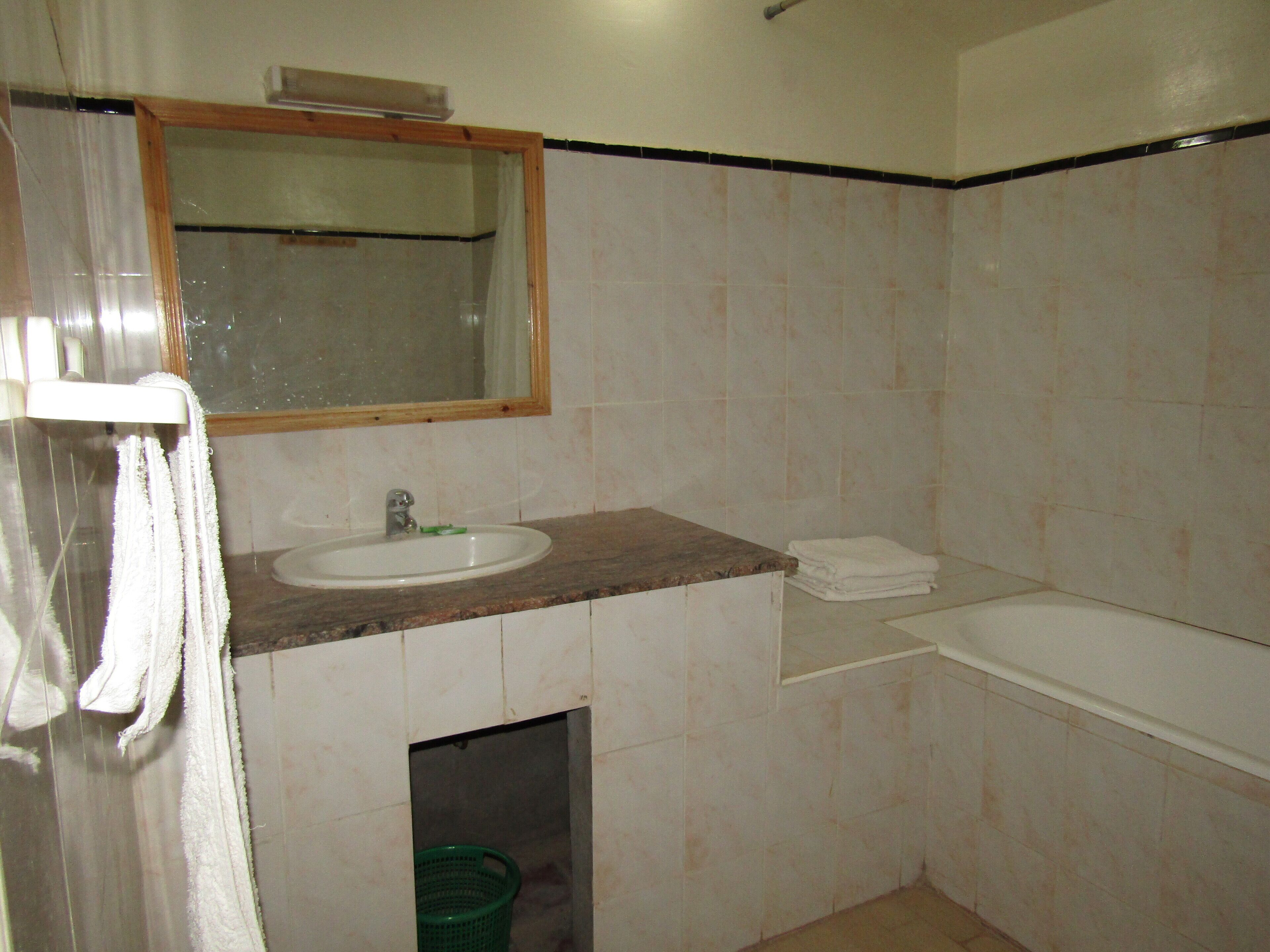 Un baño con lavamanos, espejo y bañera.