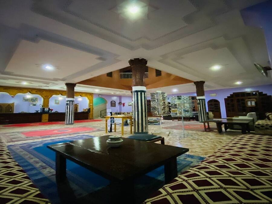 A spacious lobby with a high ceiling, a central column, and a patterned carpet.