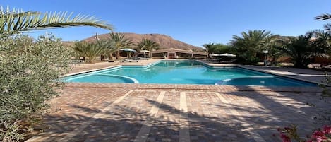 Una piscina cubierta, una piscina al aire libre, tumbonas