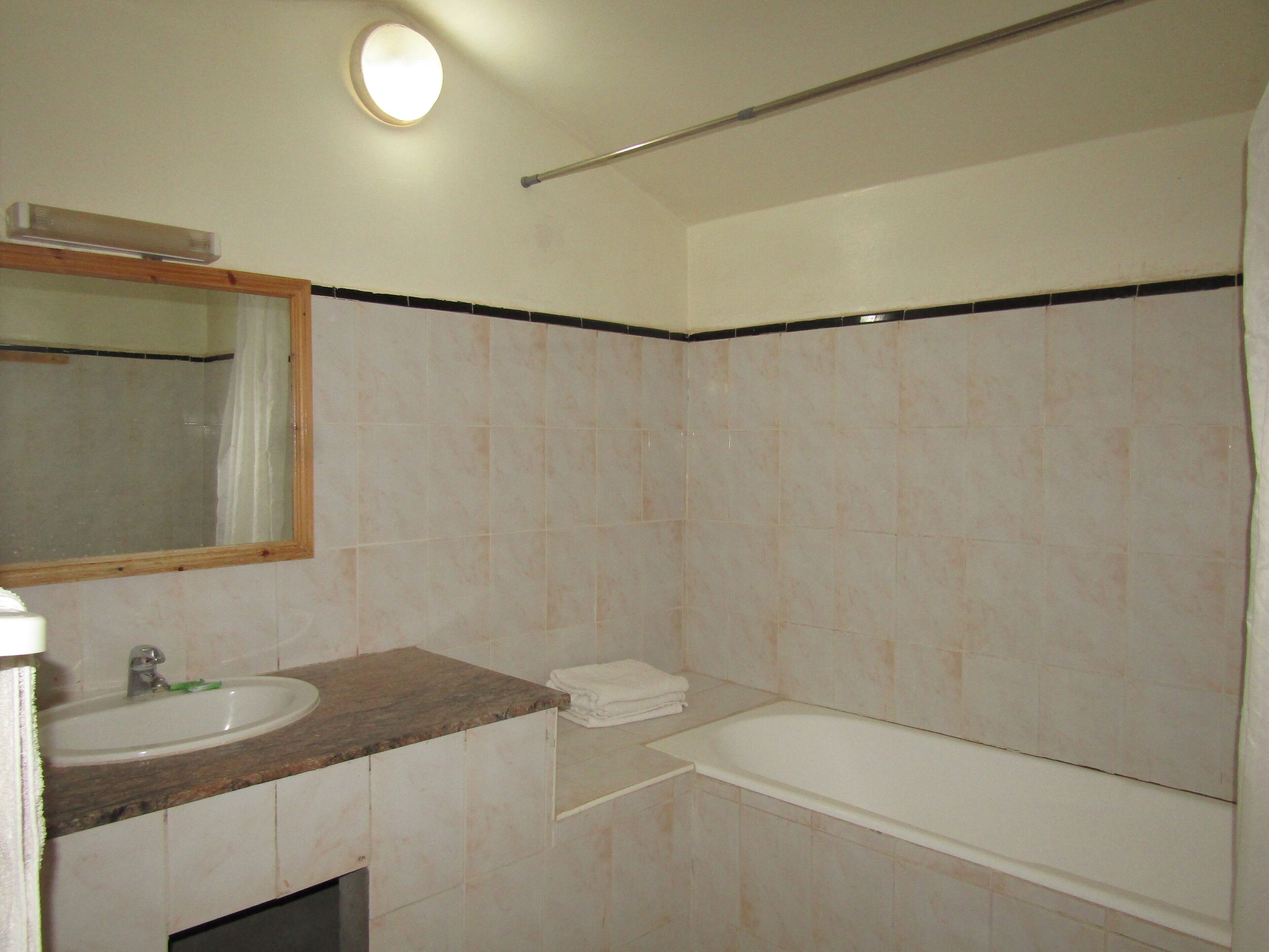Un baño con lavamanos, espejo y bañera.