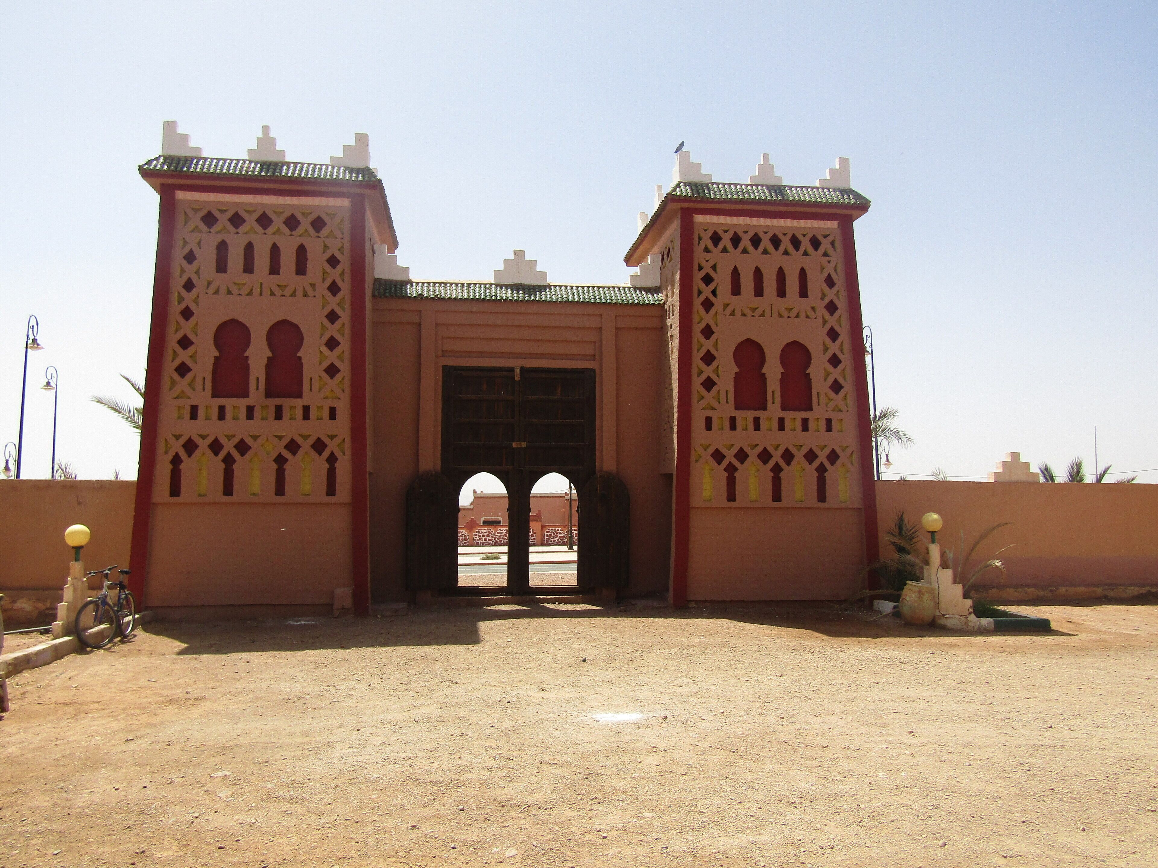 A traditional gate with intricate geometric patterns and two symmetrical towers, leading to an entrance.