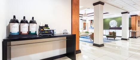 A hotel reception area with a reception desk, a coffee machine, and a water dispenser.