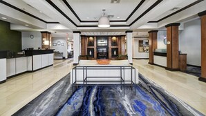 Um hall de hotel com balcão de recepção, área de estar e lareira.