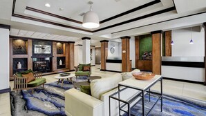 Um hall amplo com lareira, área de estar e mesa de jantar.
