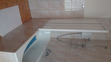 Een badkamer met een bad, een douche en een toilet.