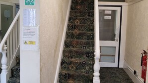 A carpeted staircase with a caution sign, a private door, and a fire extinguisher.